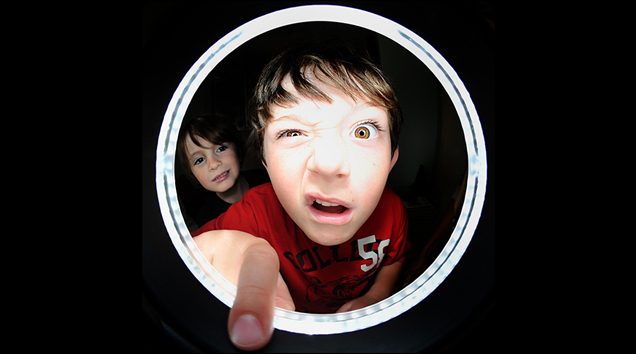 boy looking into the ring lens of a camera